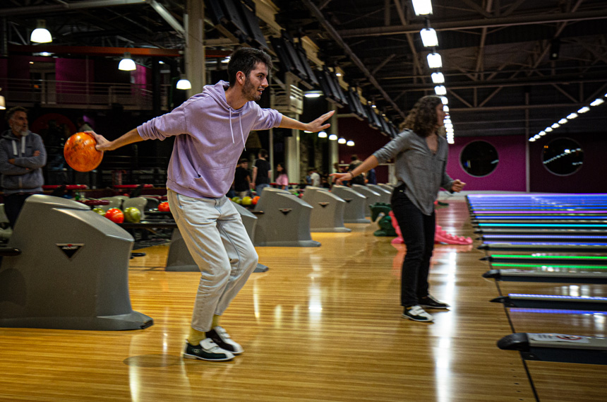 Jeune homme en pull mauve dansant sur Tata Yoyo dans un bowling.