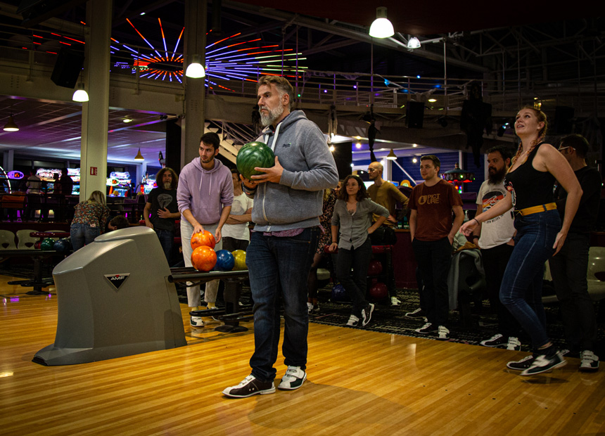 Un gérant d'agence digitale concentré pour une partie de bowling