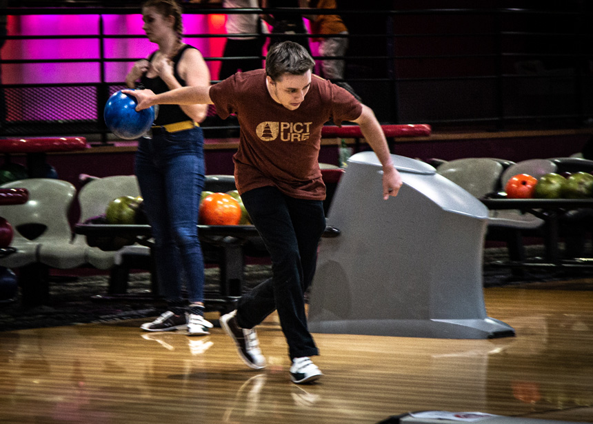 Jeune homme s'élançant sur la piste de bowling.